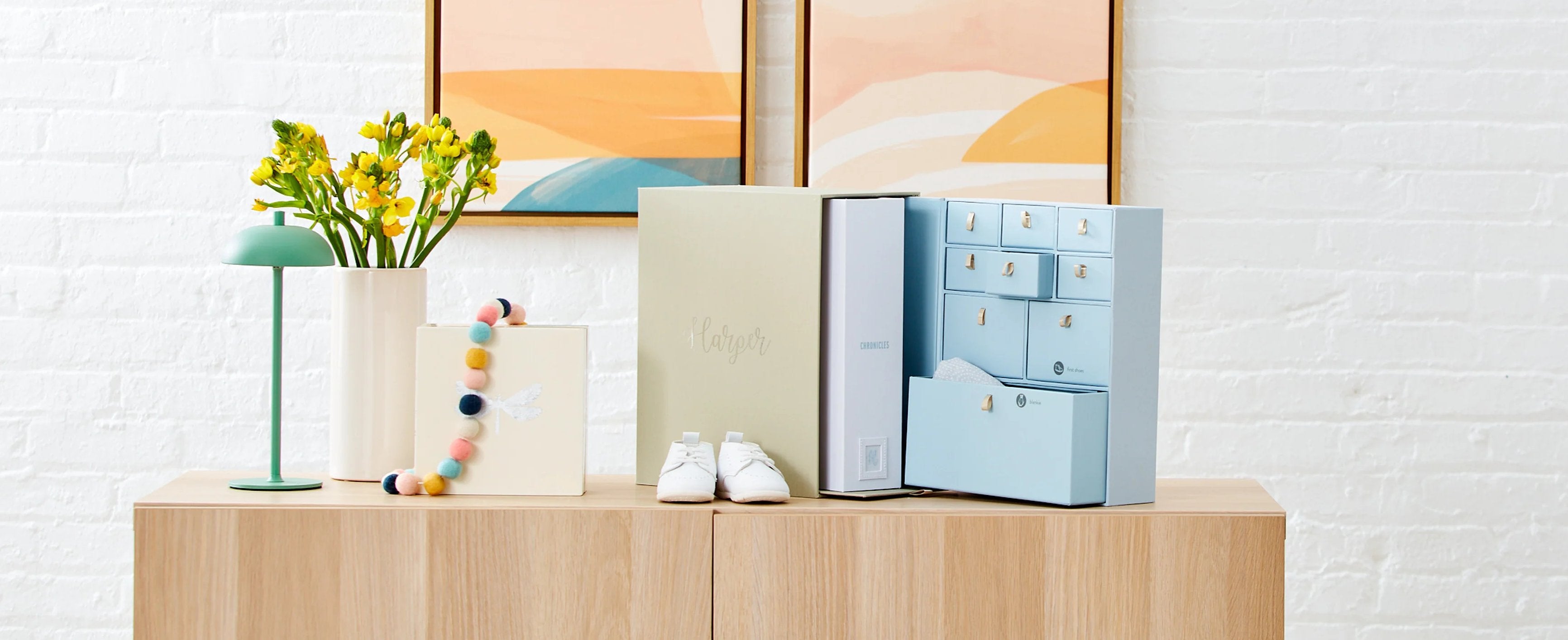 Slate color box set of a newborn with a baby picture on top and baby clothes inside over a table.