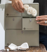close up of drawers in deluxe keepsake box, with someone placing a wedding momento inside.