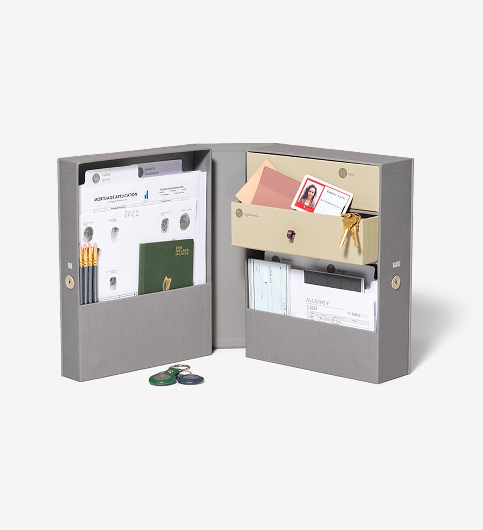 Gray and beige Savor organizer keepsake box open with fingerprints, medals and other items inside on seamless background