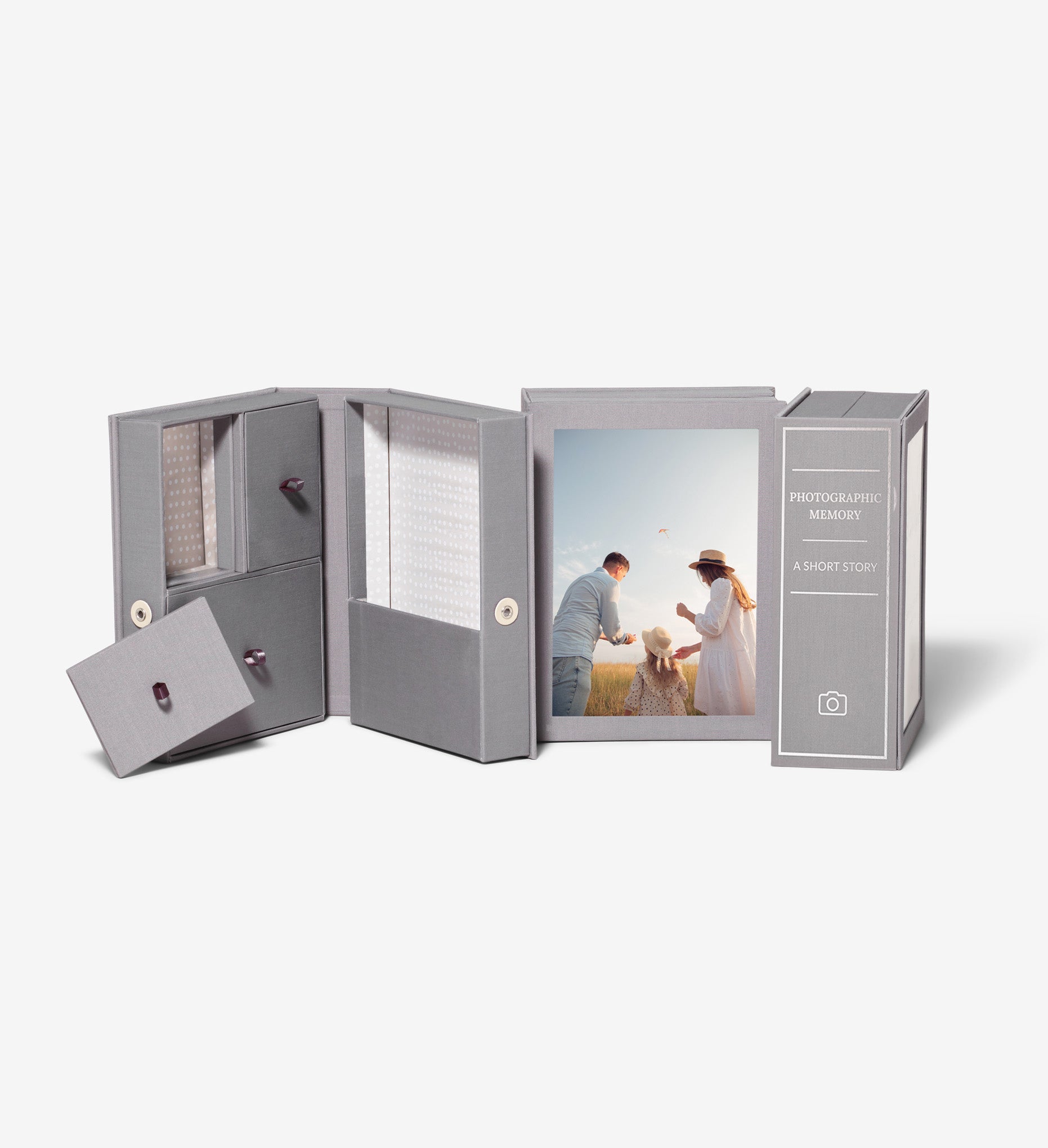 three slate story boxes, one is open, one is showing a photo of a family and one is showing a personalized spine