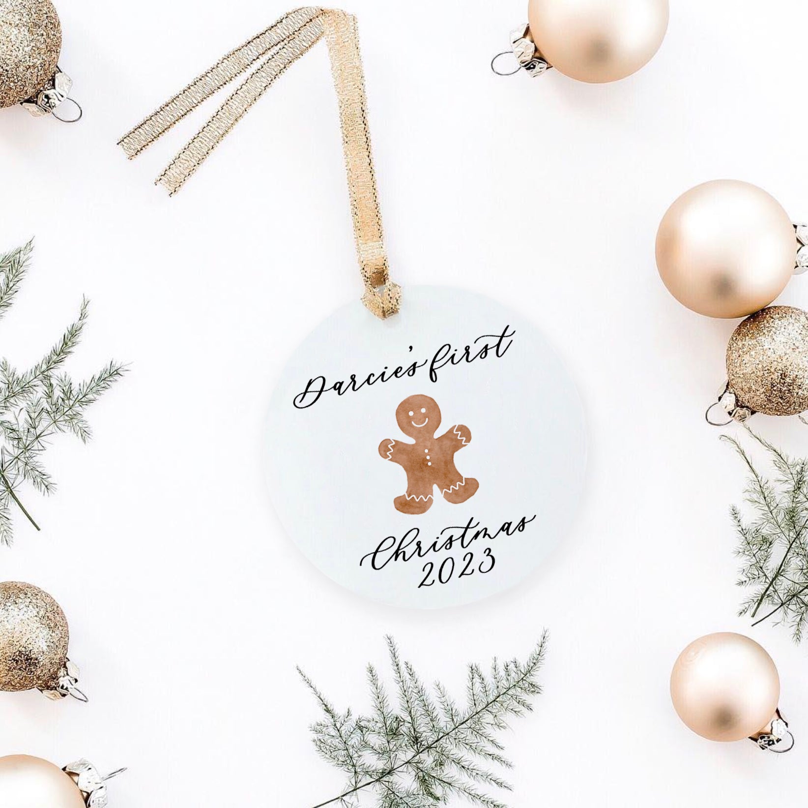 a christmas ornament personalized with laura and a gingergread cookie and christmas props.