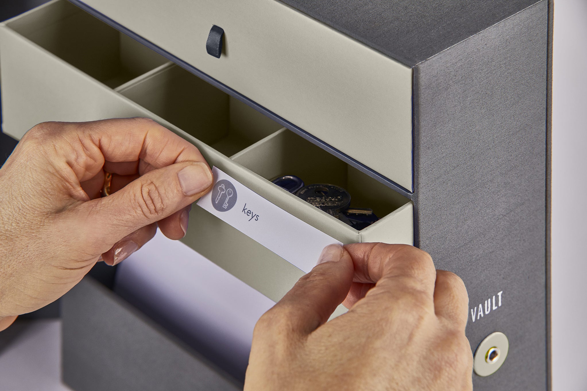Someone applying a label on a beige drawer