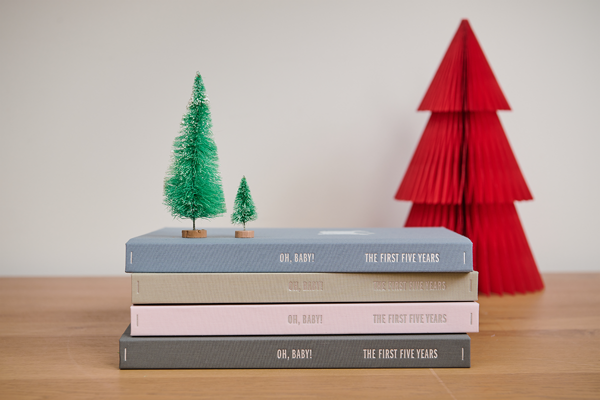Slate color box set of a newborn with a baby picture on top and baby clothes inside over a table.