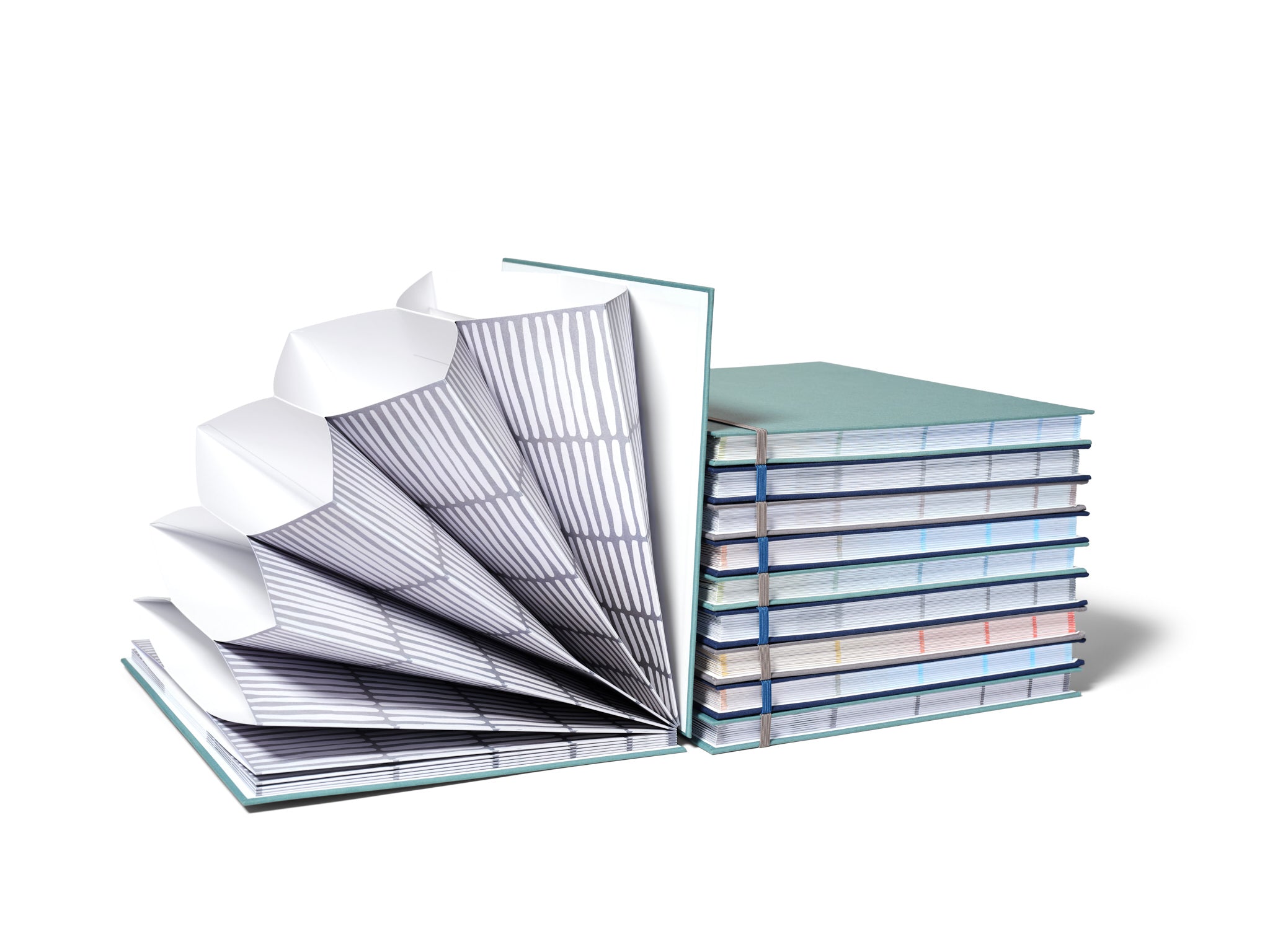 Savor Fan folios, one open leaning against nine stacked