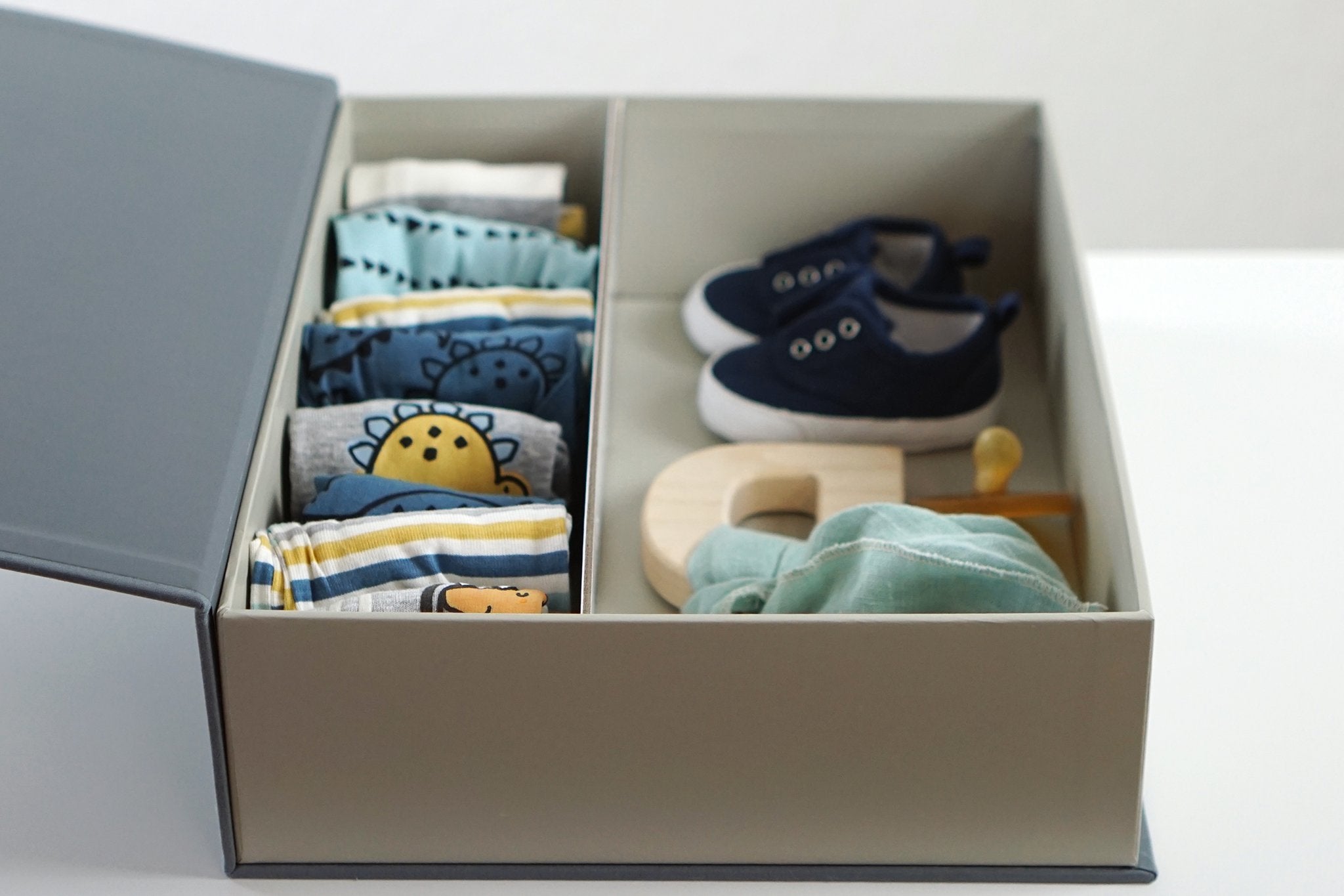 open slate overflow box with baby clothes