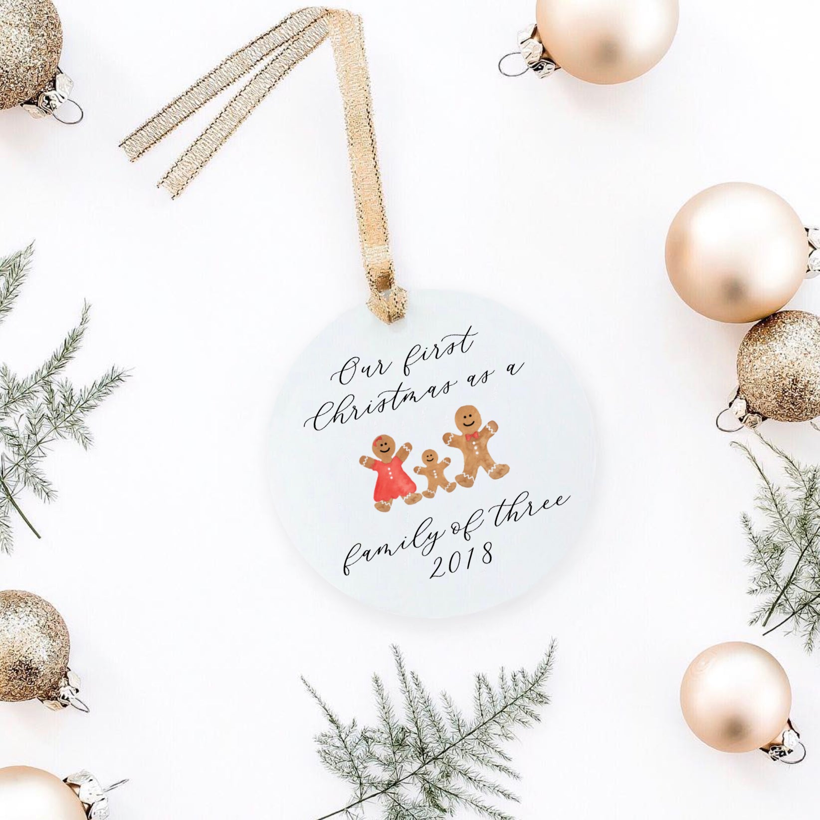 christmas ornament with a tree and a personalization in laura. Christmas props around it